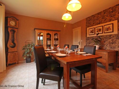 a dining room with a wooden table and chairs at Maison familiale avec jardin clos près du Haras National du Pin - FR-1-497-173 in Le Merlerault