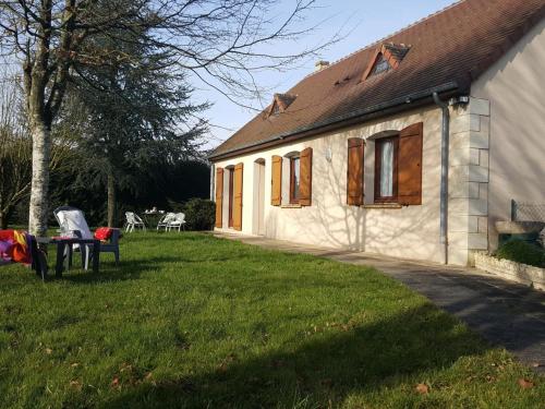 a small white house with a table in the yard at Maison familiale avec jardin clos près du Haras National du Pin - FR-1-497-173 in Le Merlerault