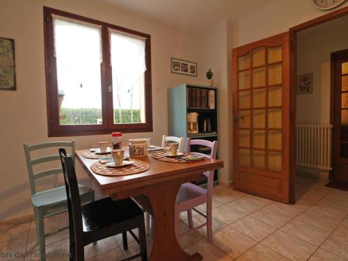 a dining room with a wooden table and chairs at Maison familiale avec jardin clos près du Haras National du Pin - FR-1-497-173 in Le Merlerault