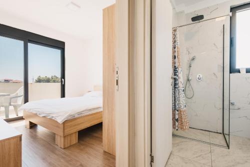 a bedroom with a bed and a glass shower at Apartment L'ideal in Ulcinj