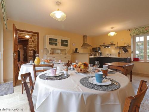a kitchen and dining room with tables and chairs at Retraite paisible en maison traditionnelle, 4 chambres, jardin arboré, cheminée et nature luxuriante. - FR-1-497-154 in Saint-Cornier-des-Landes