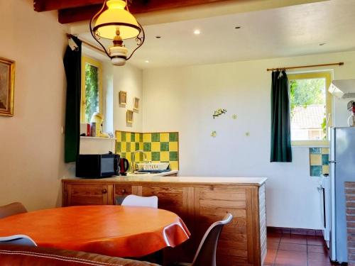 une cuisine avec une table en bois et une salle à manger dans l'établissement Gîte confortable à la ferme avec WIFI et animaux admis - FR-1-510-229, à Météren