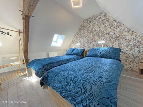 two beds in a bedroom with blue comforter at Charmante maison près de Domfront avec 3 ch, animaux admis - FR-1-497-201 in Saint-Gilles-des-Marais
