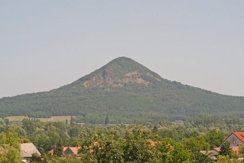 a mountain in the distance with houses and trees at Bazaltorgona Apartman in Kisapáti