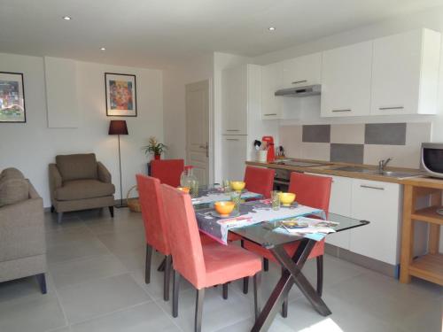 a kitchen and dining room with a table and red chairs at Charmant Gîte dans les Monts du Lyonnais avec Jardin, Terrasse et Confort Moderne - FR-1-496-174 in Maringes