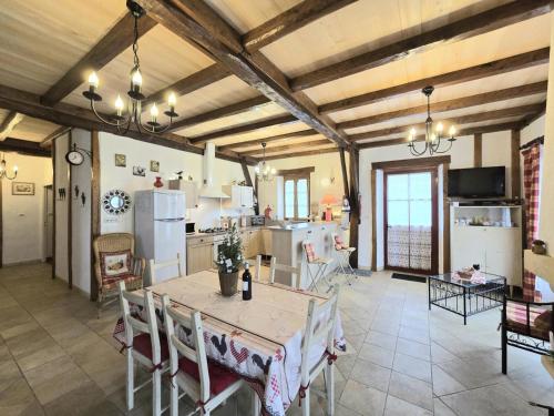 une cuisine et une salle à manger avec une table et des chaises dans l'établissement Maison 2 Chambres avec Jardin, Animaux Acceptés, Parking, WiFi à Mazeyrolles - FR-1-616-106, à Mazeyrolles