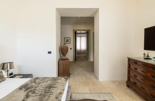 a bedroom with a bed and a dresser and a hallway at La Dépendance Hotel in Noto