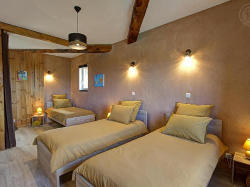 a bedroom with two beds in a room at Gîte spacieux avec piscine et spa en pleine campagne - FR-1-496-296 