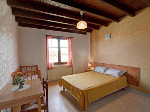 Gîte familial avec jeux extérieurs près de St-Galmier - FR-1-496-281 في Saint-Médard-en-Forez: غرفة نوم بها سرير وطاولة ونافذة
