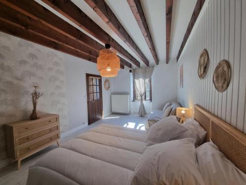 a bedroom with a large bed and a wooden ceiling at Gîte 12 Pers. Charme Piscine Intérieure Chauffée, Salle de Jeux - FR-1-496-346 in Saint-Priest-la-Prugne