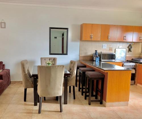 a kitchen with a table and chairs in a room at WanderHome - 1RM in Kampala