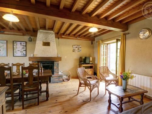 un salon avec une table et une cheminée dans l'établissement Chalet familial à 5 min des pistes de ski de Chalmazel, 3 chambres, cheminée, animaux acceptés - FR-1-496-138, à Le Champas