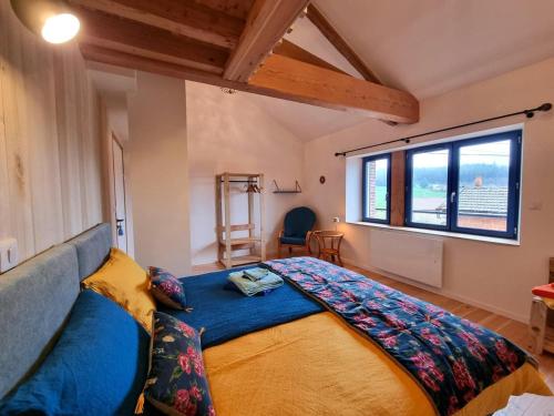 une chambre avec un grand lit avec une grande fenêtre dans l'établissement Gîte écologique de charme au Cergne, idéal famille et randonneurs - FR-1-496-351, à Le Cergne
