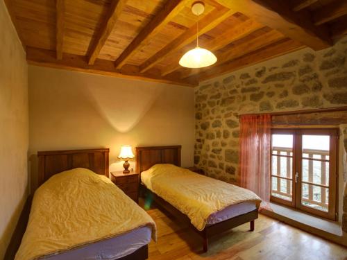 una camera da letto con due letti e una finestra di Charmant Gîte avec Terrasse, Cheminée et Jardin, à Proximité des Bois, Animaux Acceptés - FR-1-496-205 a Saint-Jean-Soleymieux