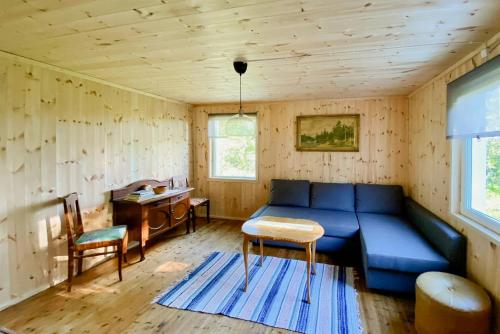 a living room with a blue couch and a desk at Rural Magic In The Heart Of Nature in Krokströmmen
