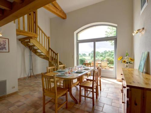 une salle à manger avec une table et des chaises et une fenêtre dans l'établissement Grande Maison Authentique avec Jardin Privé, Terrasse et VTT - Hébergement pour 15 Personnes - FR-1-496-109, à Luré