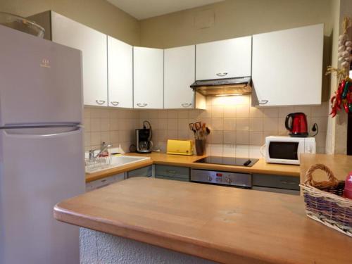 une cuisine avec des armoires blanches et un réfrigérateur blanc dans l'établissement Gîte de Charme avec Parc, Tennis et Salle de Jeux près d'un Château à Parigny - FR-1-496-160, à Parigny