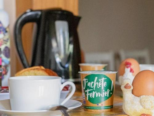 a table with cups of coffee and eggs on it at Gîte Rustique avec Terrasse, Jardin Privatif et Visite de Ferme à Vêtre-sur-Anzon - FR-1-496-290 in Saint-Julien-la-Vêtre