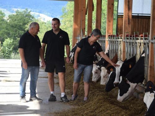 three men are looking at cows in a barn at Gîte Rustique avec Terrasse, Jardin Privatif et Visite de Ferme à Vêtre-sur-Anzon - FR-1-496-290 in Saint-Julien-la-Vêtre