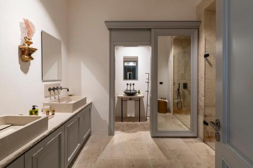 a bathroom with two sinks and a shower at La Dépendance Hotel in Noto