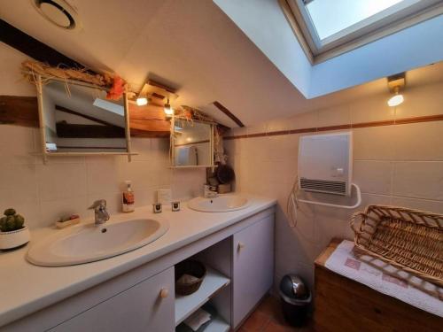 a bathroom with two sinks and a mirror and a window at Gîte charmant avec jardin privatif, proche sites historiques et activités de plein air - FR-1-496-183 in Cuinzier