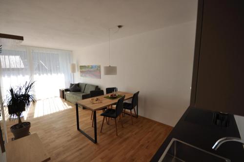 a living room with a table and chairs and a couch at Alpenchalet Apartments in Parcines