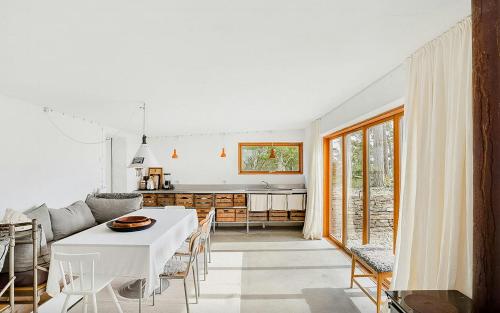 a kitchen and living room with a white table and chairs at Sea View And Idyll In Bungenäs On Gotland in Fårösund