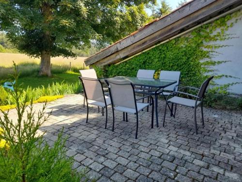 a table and chairs on a brick patio at Gîte chaleureux avec poêle à bois, terrasse, wifi, proche activités nature - FR-1-496-268 in Saint-Régis-du-Coin