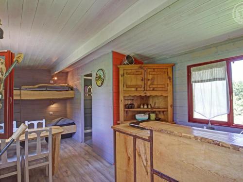 Cette chambre comprend une cuisine et des lits superposés. dans l'établissement Roulotte chaleureuse pour 4 pers., paisible, avec étang, animaux, proche de Roanne - FR-1-496-308, à Saint-Germain-Lespinasse