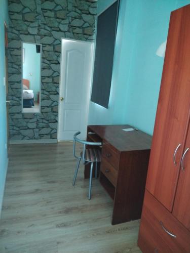 a kitchen with a desk and a stone wall at Ayelen Express in Calama