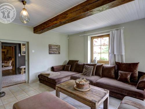 a living room with a couch and a table at Gîte familial 14 pers. avec piscine chauffée, spa, sauna, terrains de jeux et borne électrique. - FR-1-496-3 in Vivans