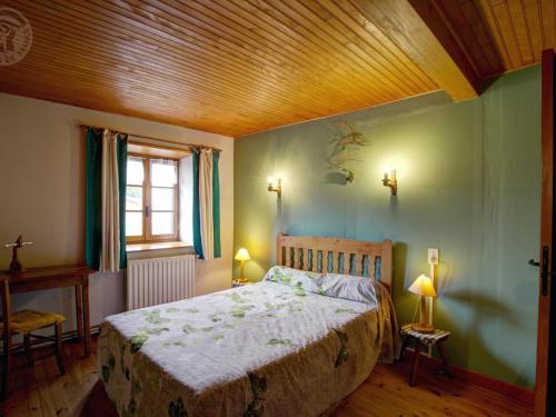 una camera da letto con un letto e un soffitto in legno di Gîte rénové avec cheminée et jardin à 15 km des pistes de ski - FR-1-496-9 a Saint-Bonnet-le-Courreau