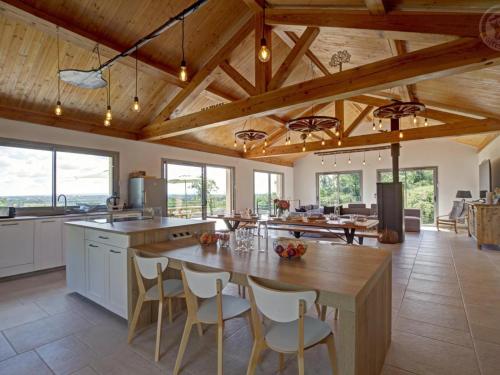 a kitchen with a large wooden table and chairs at Grande maison rénovée avec piscine chauffée, salle de jeux, pour 14 pers. à Sail-les-Bains - FR-1-496-301 in Sail-les-Bains