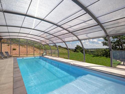 a swimming pool under a retractable roof at Grande maison rénovée avec piscine chauffée, salle de jeux, pour 14 pers. à Sail-les-Bains - FR-1-496-301 in Sail-les-Bains