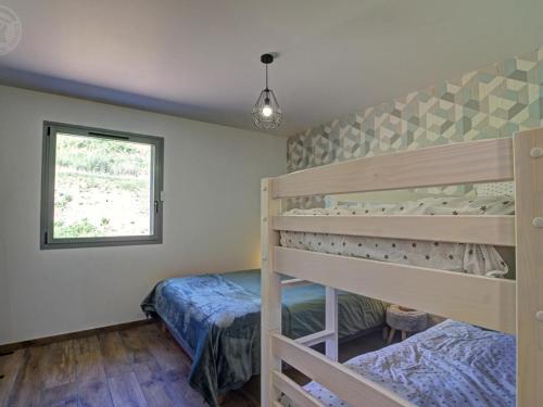 a bedroom with two bunk beds and a window at Grande maison rénovée avec piscine chauffée, salle de jeux, pour 14 pers. à Sail-les-Bains - FR-1-496-301 in Sail-les-Bains