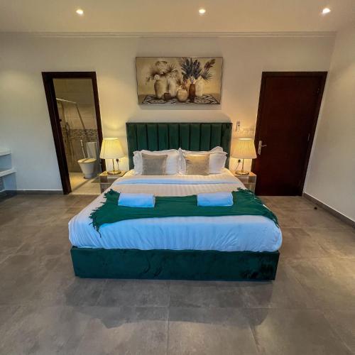 a bedroom with a large bed with a green headboard at Superior Furnished Apartments شقق مخدومة فاخرة in Jeddah