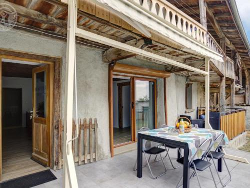 une table et des chaises sur le balcon d'une maison dans l'établissement Gîte charmant à la ferme, tout confort, proche de Roanne, idéal pour randonnées et baignades - FR-1-496-220, à Crémeaux