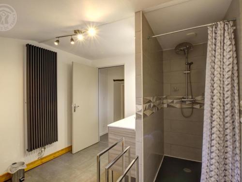 a bathroom with a shower and a bed in a room at Gîte charmant à la ferme, tout confort, proche de Roanne, idéal pour randonnées et baignades - FR-1-496-220 in Crémeaux