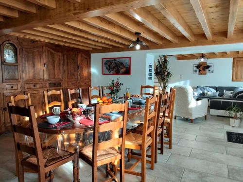 une salle à manger avec une table et des chaises en bois dans l'établissement Gîte en pierre rénové avec jardin et WiFi à Chalmazel-Jeansagnière - FR-1-496-253, à Chalmazel Jeansagniere