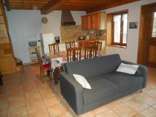un salon avec un canapé et une table dans l'établissement Gîte rustique avec cheminée, jardin et wifi - FR-1-496-175, à Aveizieux