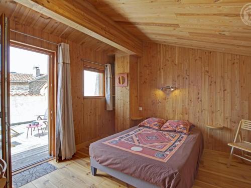 una camera da letto con un letto in una casa di legno di Gîte de charme avec terrasses et plancha - FR-1-496-327 a Verrières-en-Forez