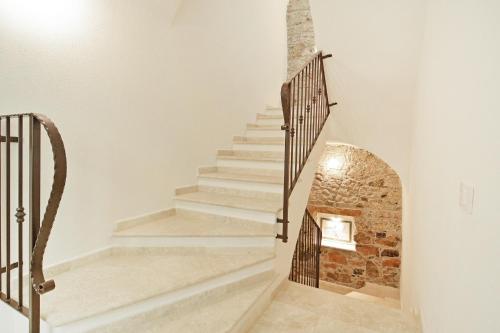 a staircase in a house with a brick wall at FIORELLI rooms in Bosa