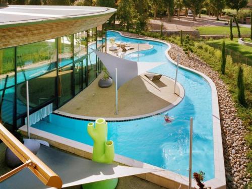 une vue aérienne d'une piscine dans un immeuble dans l'établissement Appartement Authentique et Confortable avec Wifi, Parking Gratuit et Cuisine Équipée à Saint-Galmier - FR-1-496-276, à Saint-Galmier