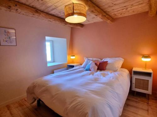 a bedroom with a large white bed with two lamps at Spacieux gîte avec bain nordique et wifi à Usson-en-Forez - FR-1-496-359 in Usson-en-Forez