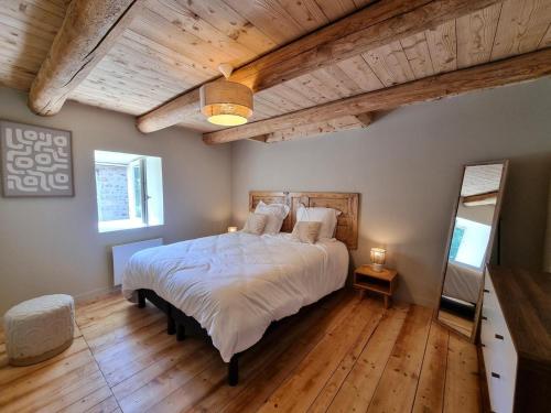 a bedroom with a large bed and a wooden ceiling at Spacieux gîte avec bain nordique et wifi à Usson-en-Forez - FR-1-496-359 in Usson-en-Forez