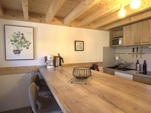 - une cuisine avec une table en bois et un comptoir dans l'établissement Gîte chaleureux avec terrasse, pêche, randonnées et équipements modernes au cœur du Haut Forez - FR-1-496-285, à Les Salles