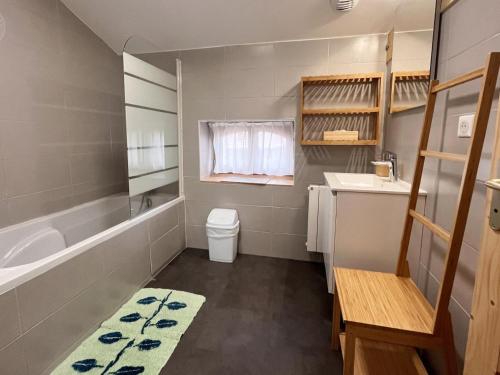 un bagno con vasca, lavandino e WC di Gîte chaleureux avec terrasse, pêche, randonnées et équipements modernes au cœur du Haut Forez - FR-1-496-285 a Les Salles