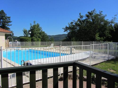 une clôture à côté d'une piscine avec une clôture gmaxwell gmaxwell gmaxwell dans l'établissement Charmant chalet 35m², 2 ch, terrasse privée, activités nature aux Monts de la Madeleine, animaux OK - FR-1-496-240, à Saint-Rirand