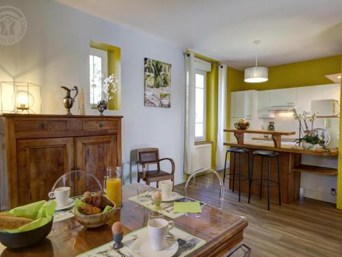 un salon avec une table et une cuisine dans l'établissement Appartement Confortable avec Jardin Privatif, Terrasse et Équipements Modernes - FR-1-496-194, à Andrézieux-Bouthéon
