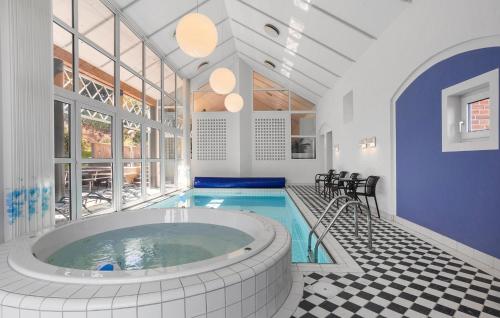 a large pool with a hot tub in a room at Five Bedroom Beautiful Home In Sindal in Sindal
